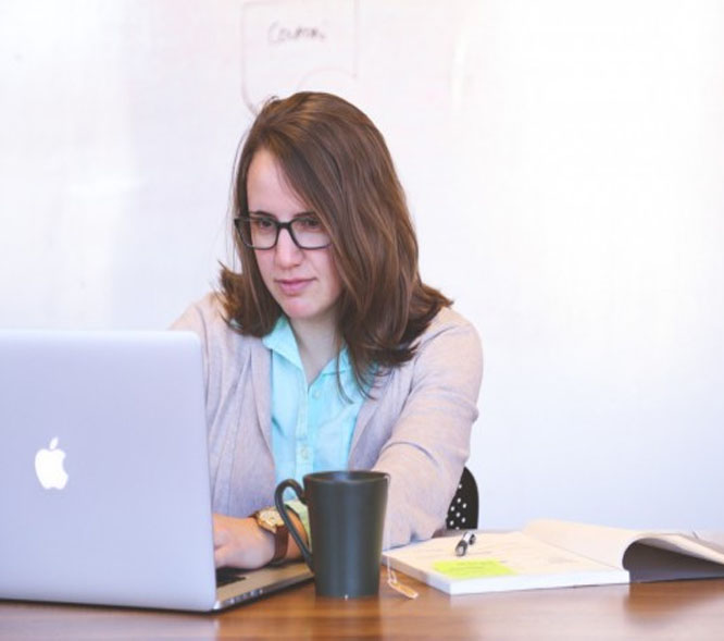A picture of Karen typing on her mac